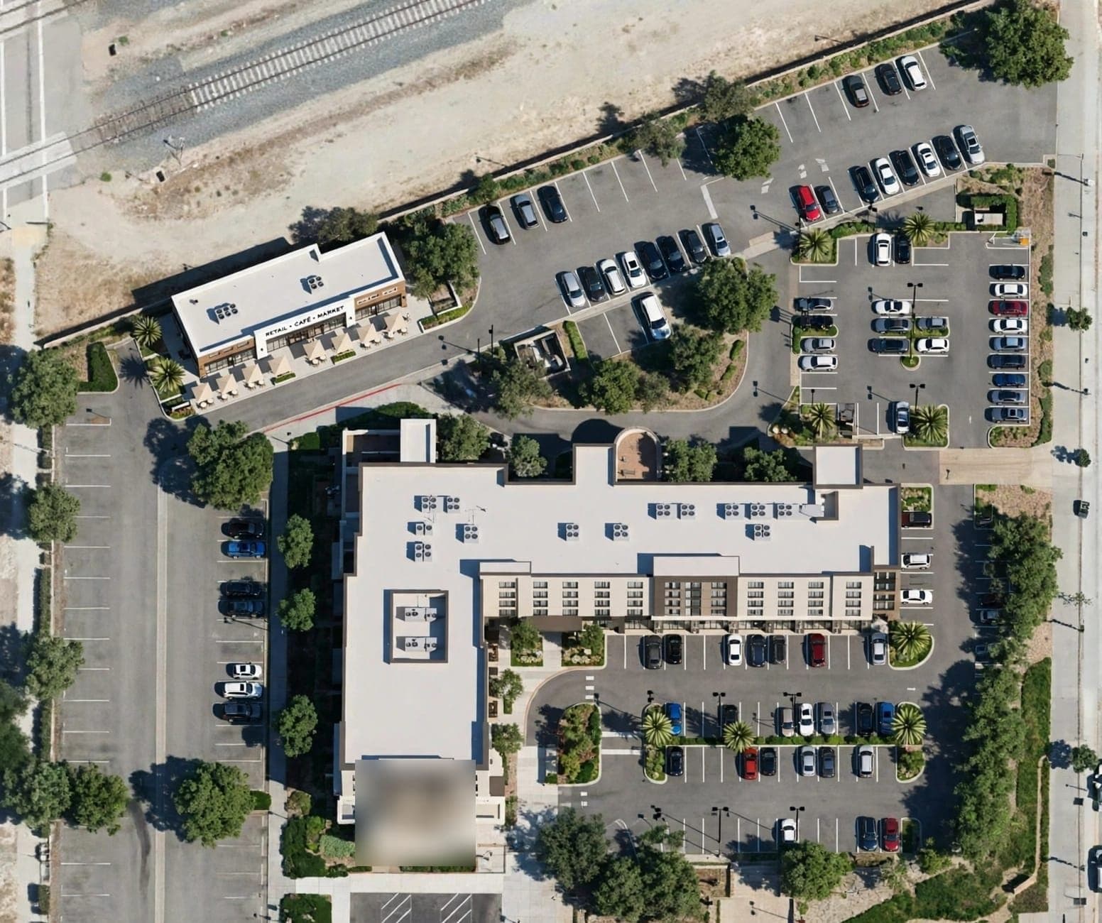 Aerial concept site plan: the hotel at the center, the café building at the northwest corner and surface parking wrapping both